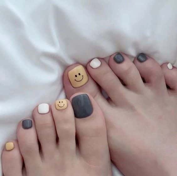 Diseños de uñas para pies -cara amarilla feliz