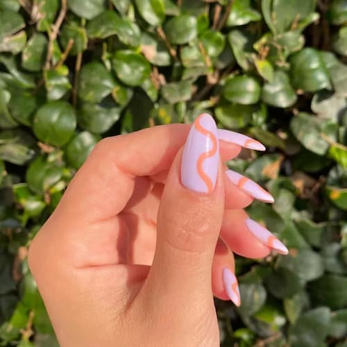 Manicura con trazos artísticos en melocotón y lavanda